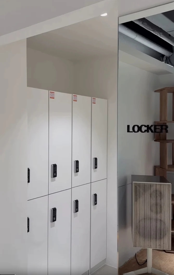 청담 미용실의 위아래로 나뉜 흰색 락커 문과 칸별 잠금장치, 옆 유리의 LOCKER 표시