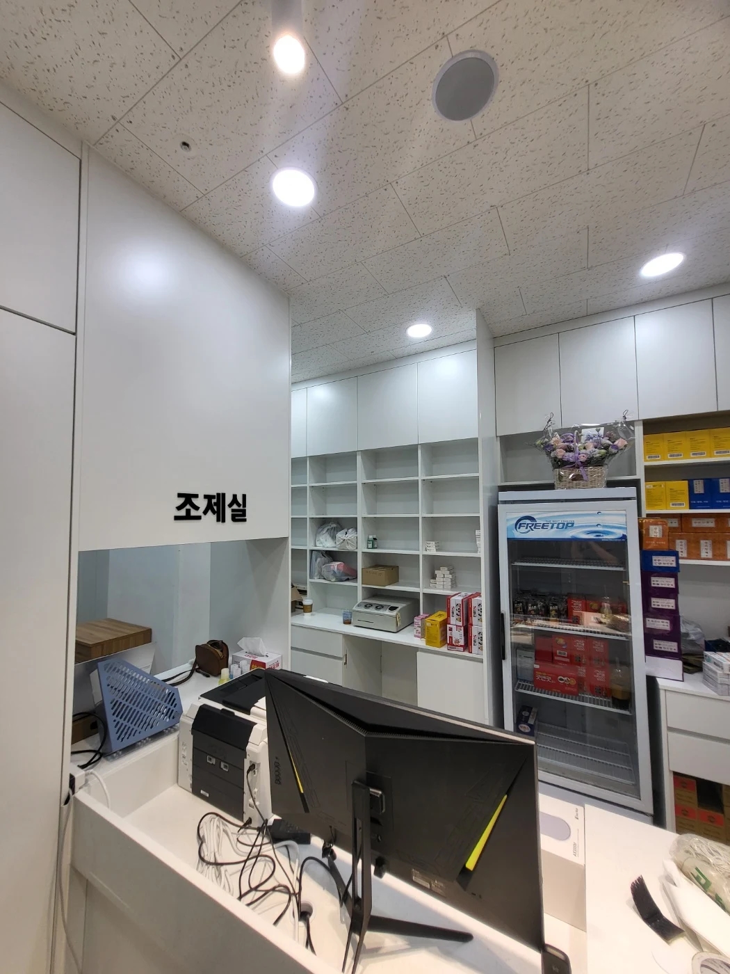 모니터와 프린터가 놓인 약국 카운터 안쪽과 조제실 입구