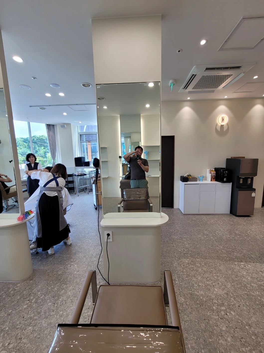 독립된 경대 앞 의자와 거울에 비친 천장 조명, 맞은편 공간이 보이는 모습